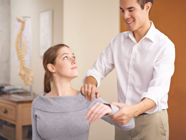 orthopedic doctor stretching a young woman's arm