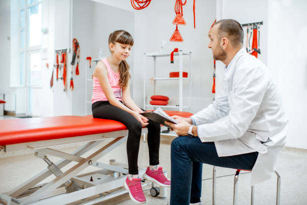 Physiotherapist during the medical consultation at the rehabilitation clinic with suspension medical equipment