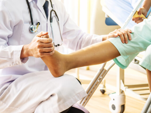 orthopedic doctor examining of the leg from the knee and ankle