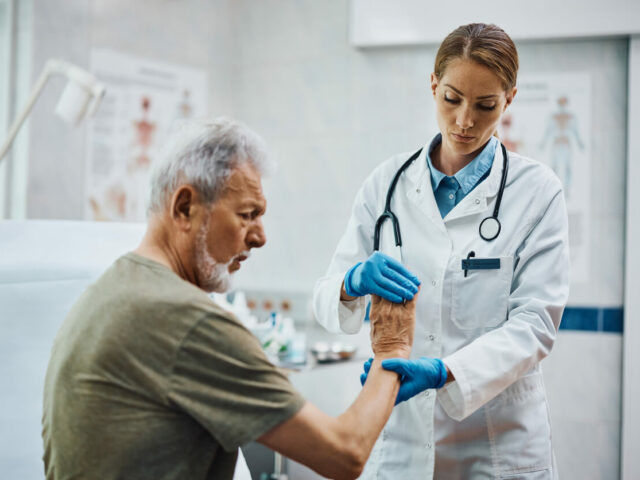 Senior patient having medical examination of at orthopedic clinic