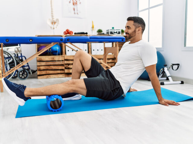 Male exercising at clinic using foam roller to prevent Osteoporosis.