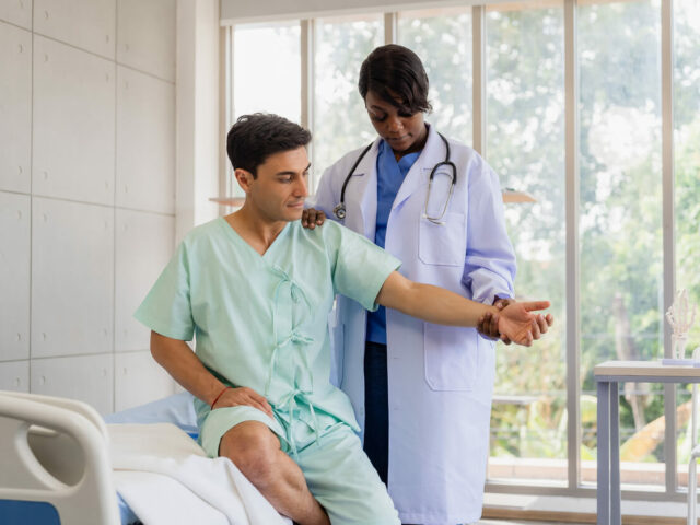 A female orthopedic doctor examining a patient's arm.